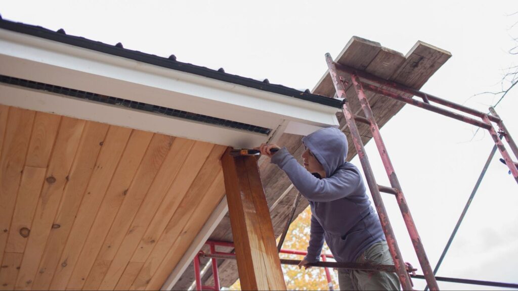 Rain Gutter expert inspecting exterior fascia and rain gutter system on a Miami home to prevent water damage